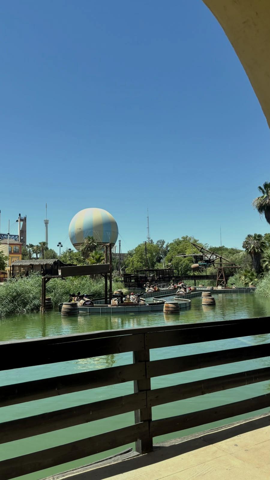A lake ringed with palm trees, a balloon in the distance.